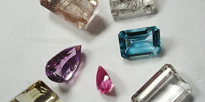 Faceted gemstones of varying tone laid out in a group for comparison.
