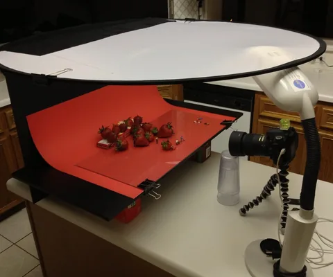 A tabletop copy stand with a diffuser and small objects arranged for photography.